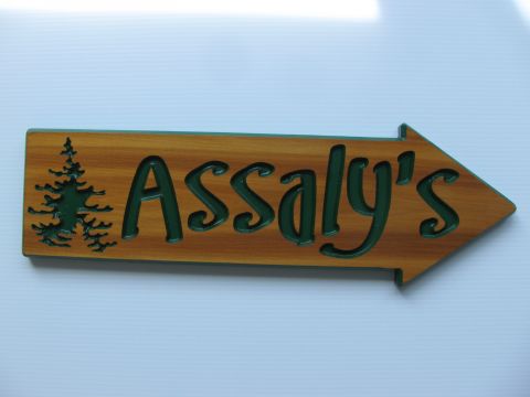 Wooden engraved directional arrows for a cottage with a graphic of a tree